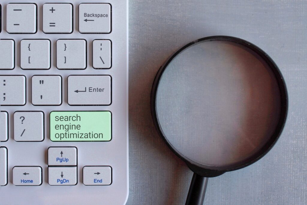 Promoting on-page SEO strategies, Top view image of magnifying glass and keyboard.